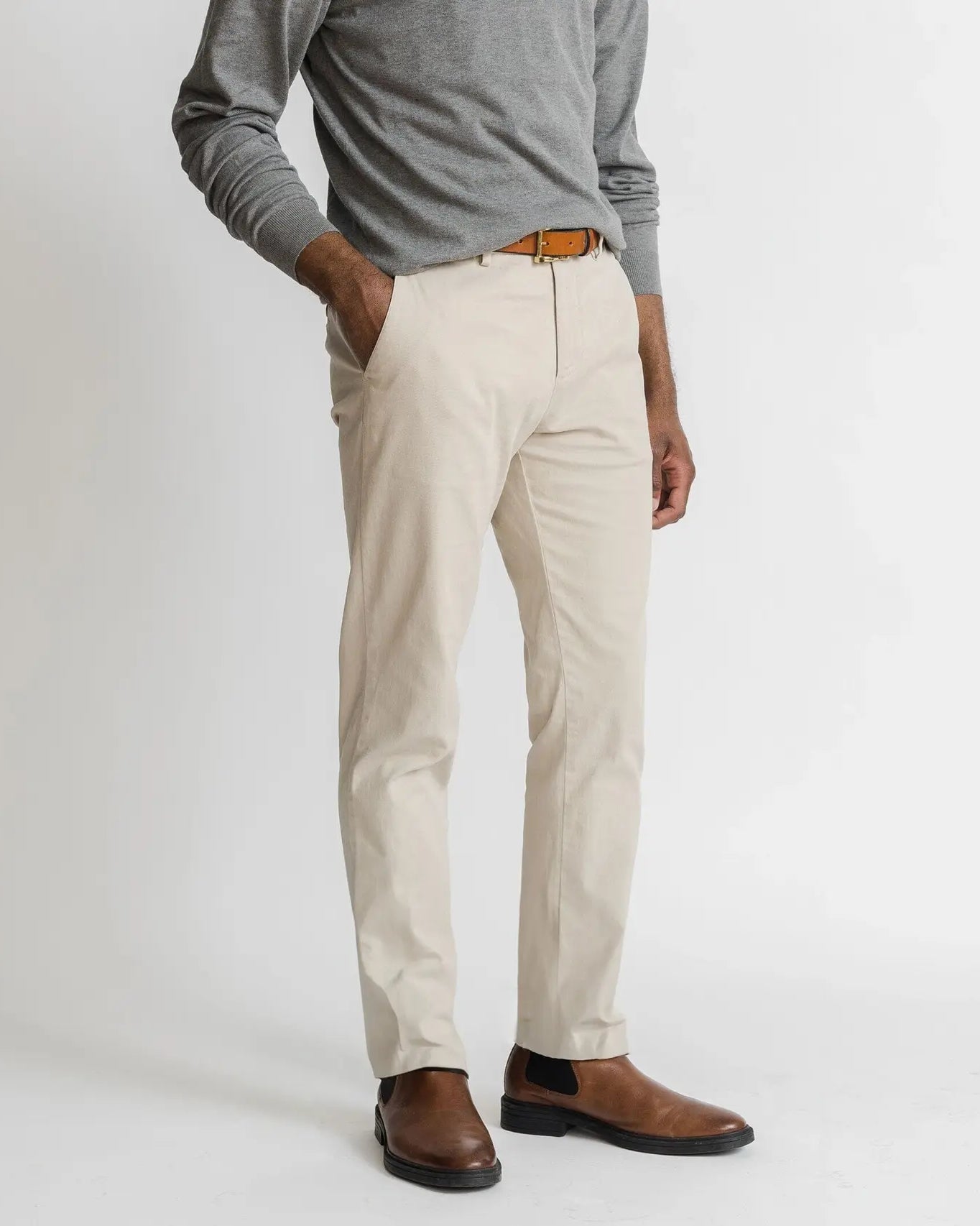 Model wearing tan richmond chinos and a lightweight grey sweater
