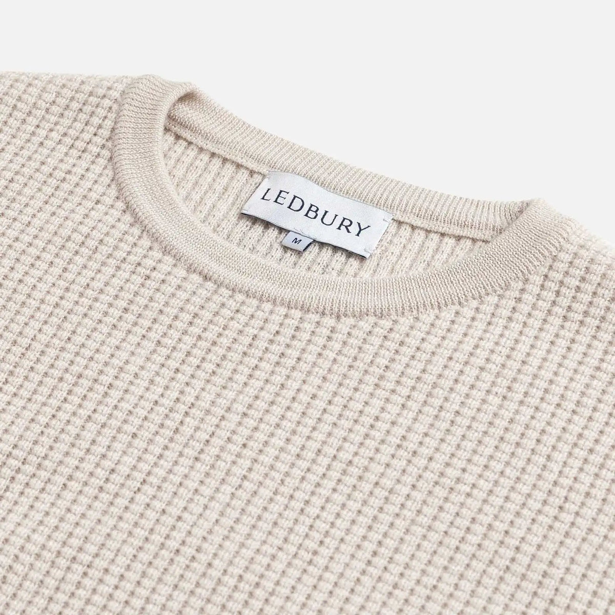 Closeup of the collar of the cream waffle knit walden sweater on a white background