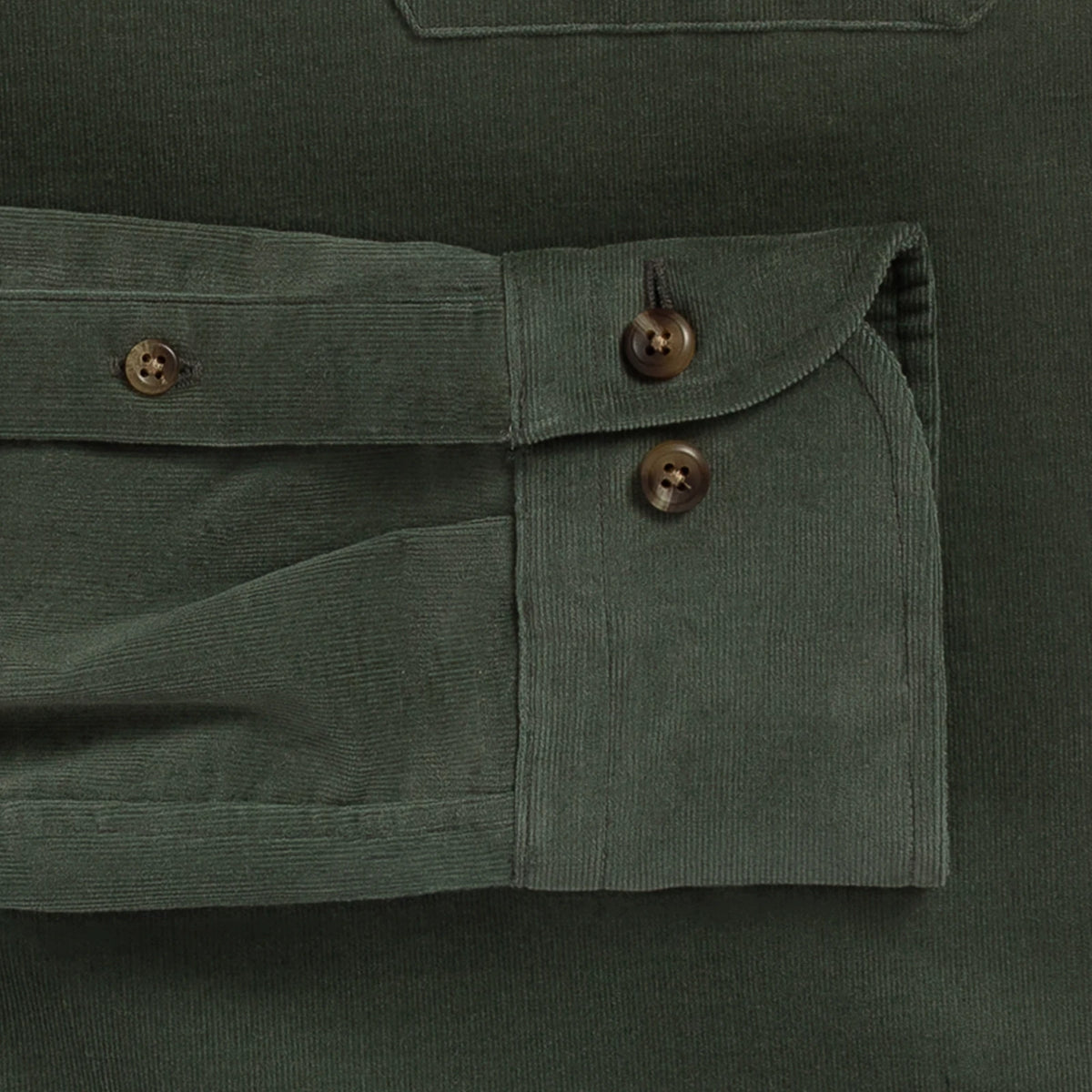 Close-up detail of an olive green corduroy shirt pocket with buttoned flap and dark brown buttons.