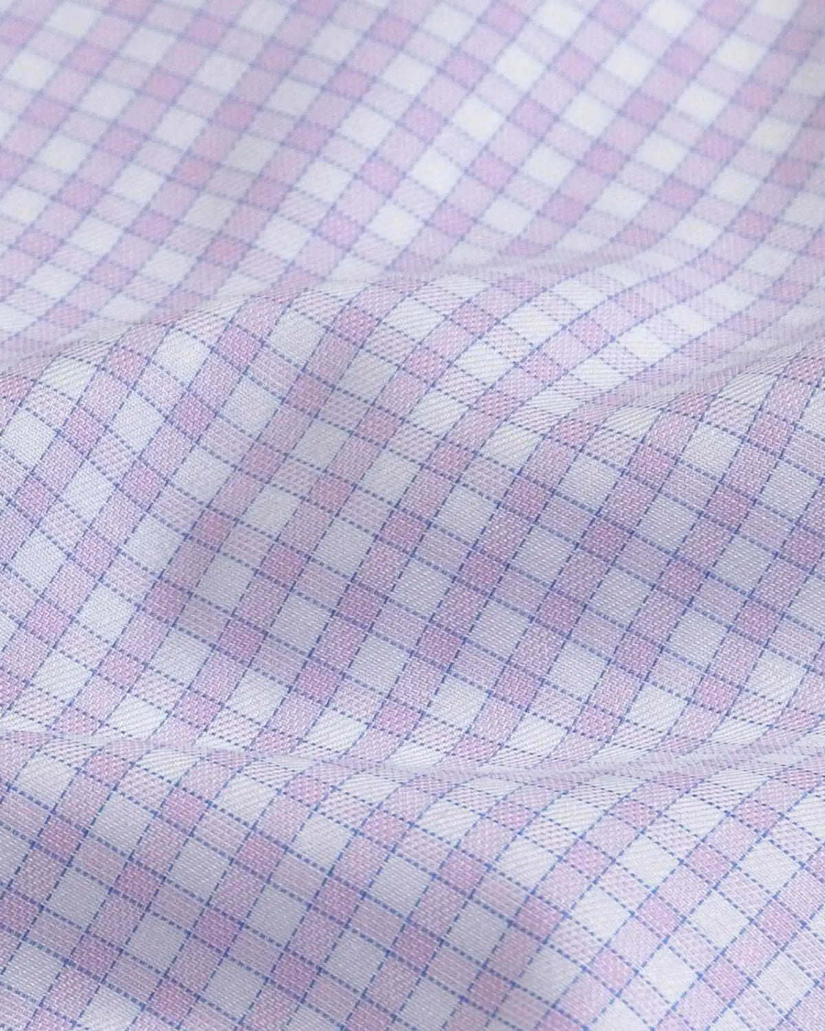 A close-up of a white fabric with a fine lavender and blue gingham check pattern, showing soft folds and texture.