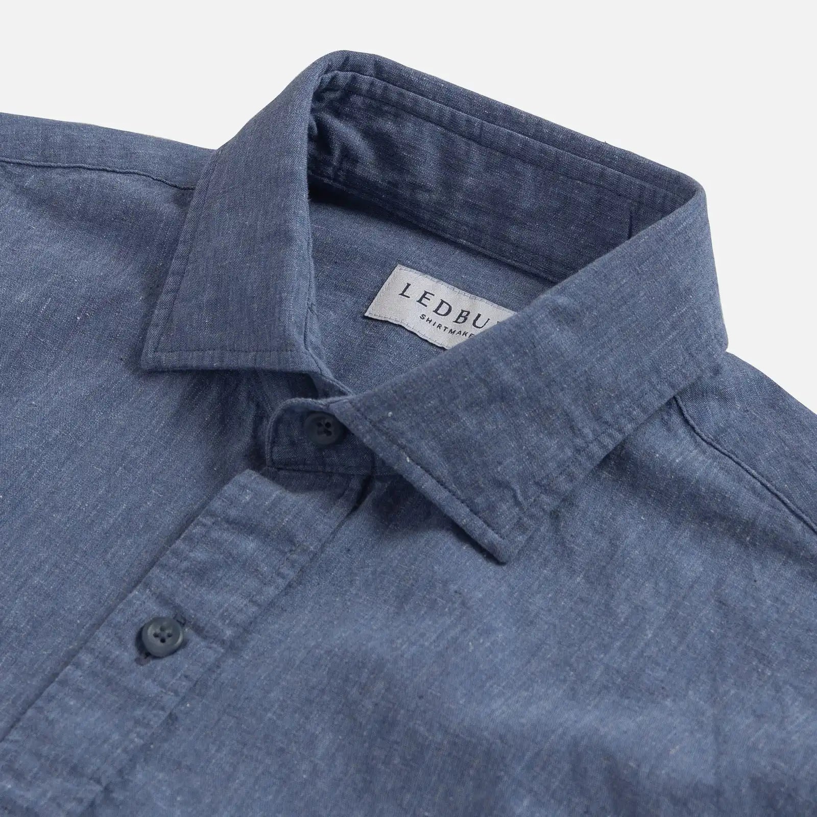 Closeup of the collar of a men's blue cotton/linen dress shirt by Ledbury