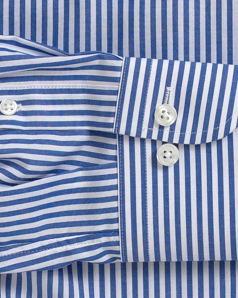 Close-up of a blue and white striped long-sleeve dress shirt cuff with two white buttons, laid flat against the matching striped fabric.