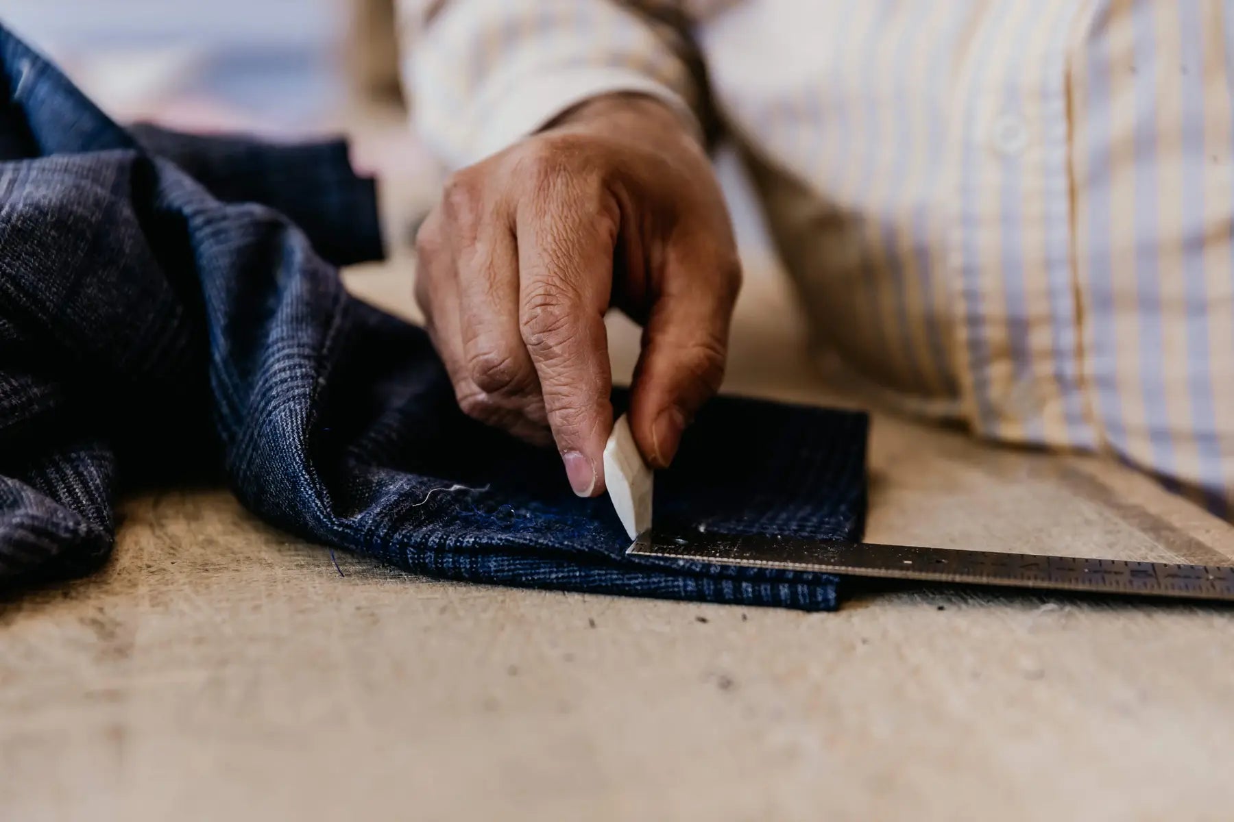 Man working in a sewing studio to shorten a shirt sleeve