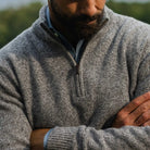 Closeup of the collar of a grey quarter zip sweater on a model