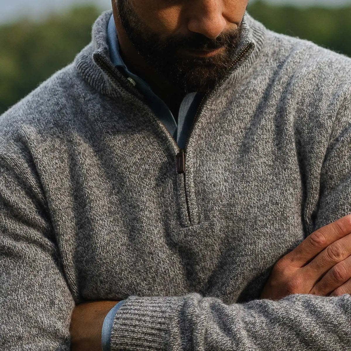 Closeup of the collar of a grey quarter zip sweater on a model