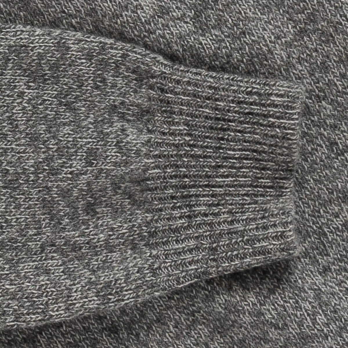 Close-up of a heather gray knit fabric with a ribbed cuff detail.
