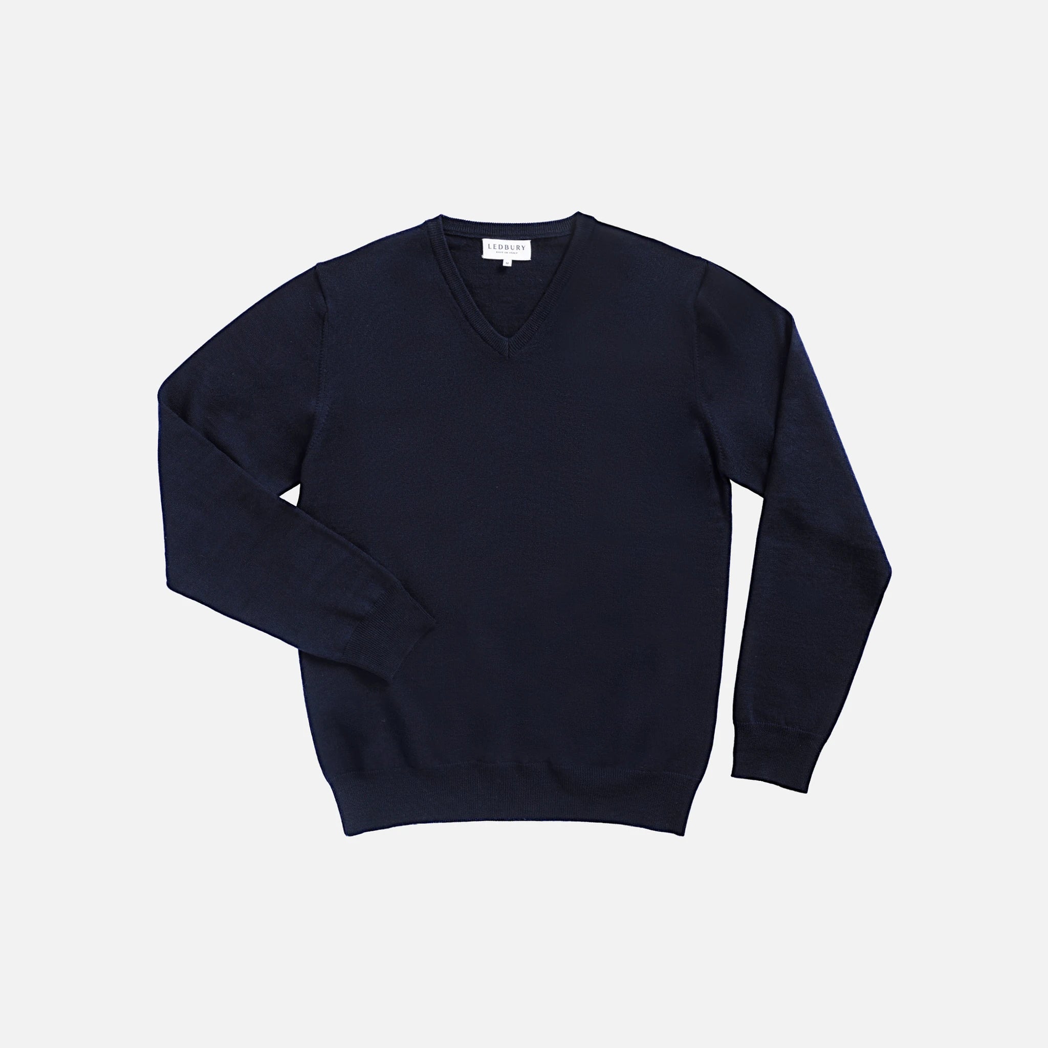 A dark navy blue V-neck knit sweater with long sleeves, laid flat against a light gray background.