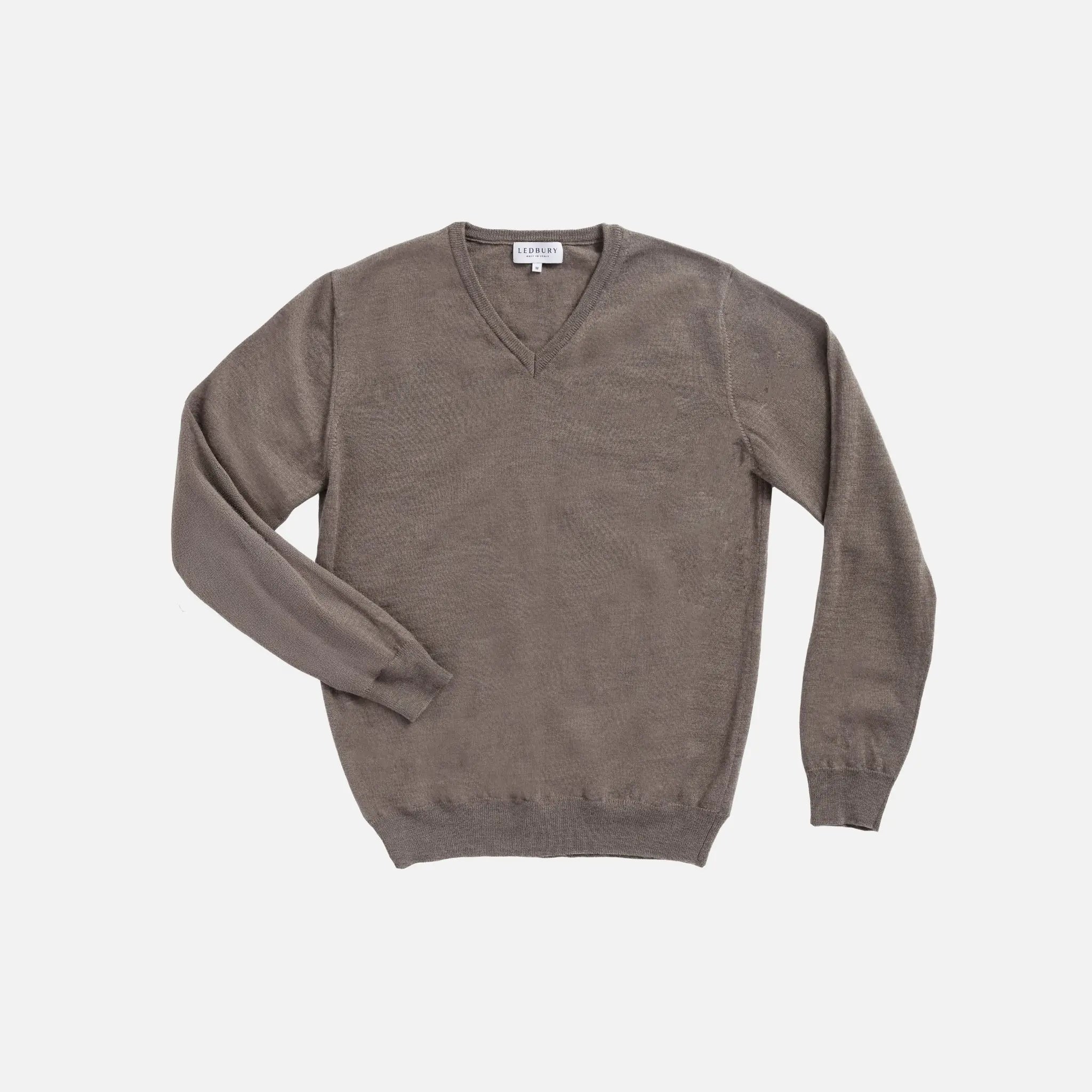 A taupe brown V-neck knit sweater with long sleeves, laid flat on a light gray background.