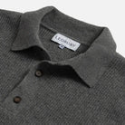 Close-up of a dark gray ribbed knit polo sweater collar with two buttons and a visible LEDBURY neck label.
