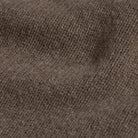Close-up of a brown 100% Italian merino wool knit sweater fabric with a fine ribbed pattern.