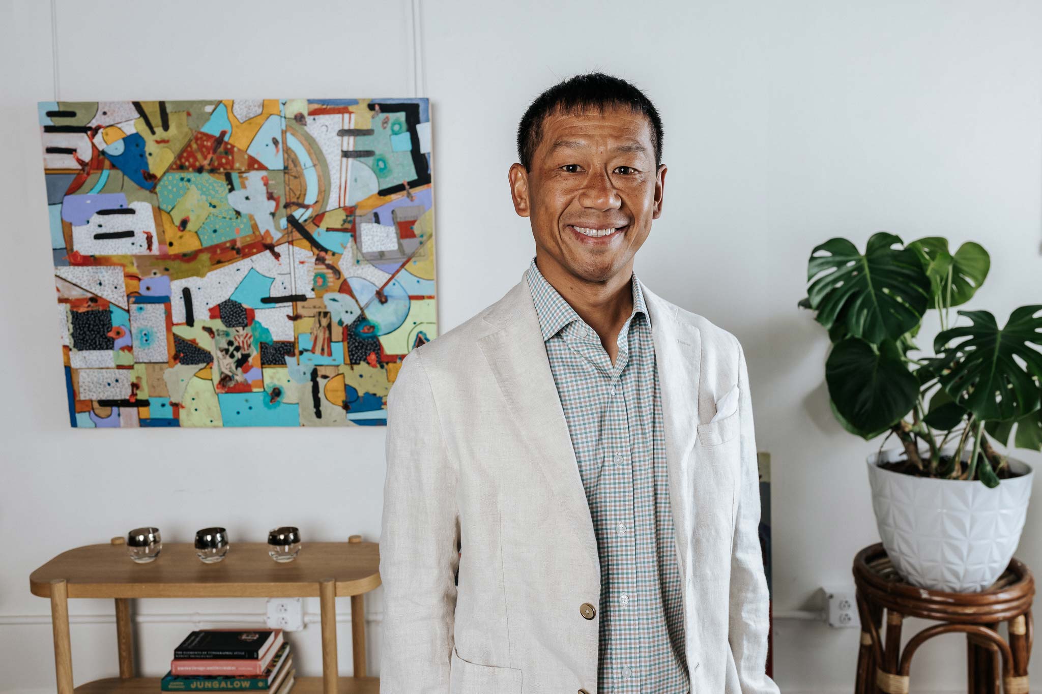 Man standing in a room with abstract art and plants
