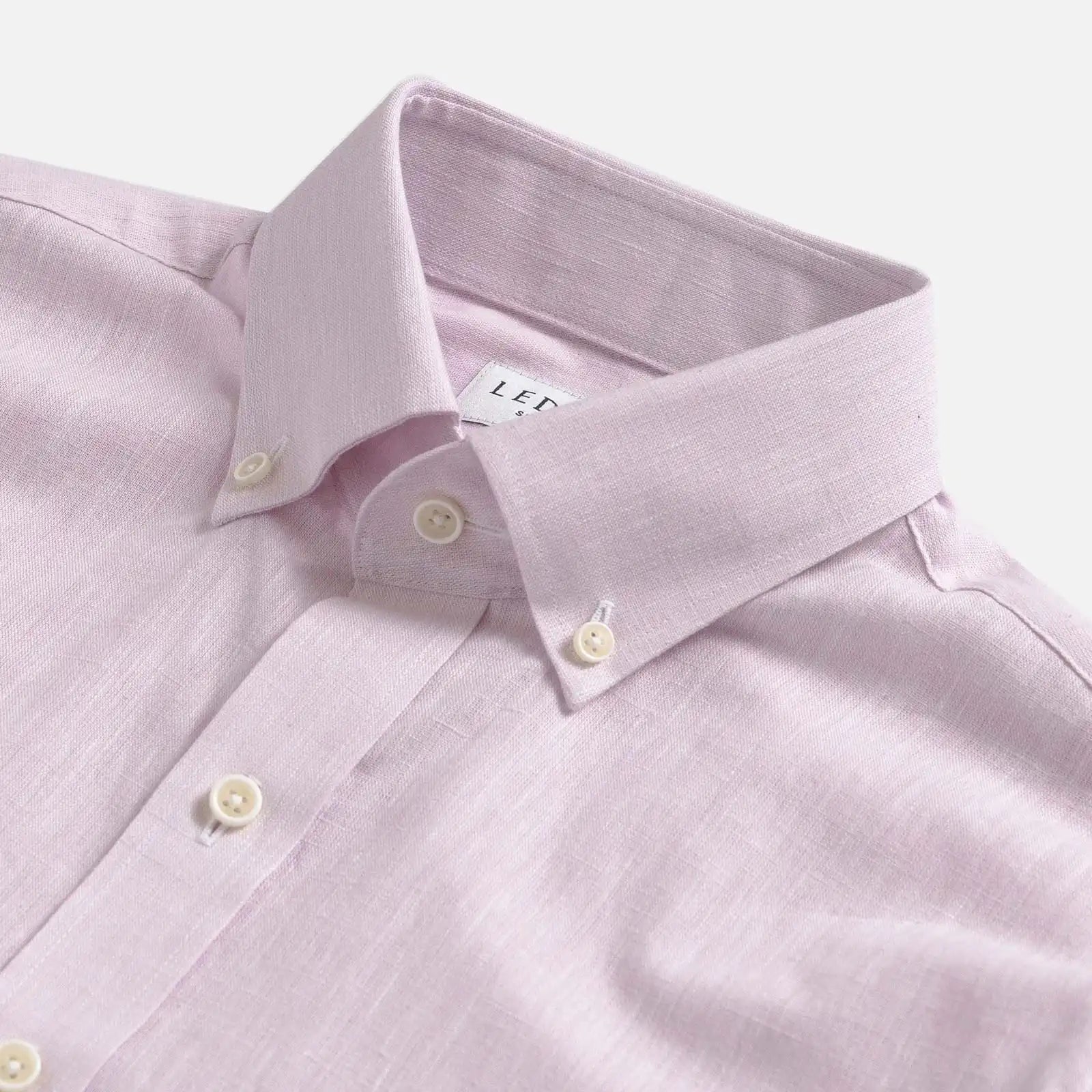 Close-up of a light pink heathered cotton oxford shirt with collar and buttons on a white background