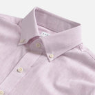 Close-up of a light pink heathered cotton oxford shirt with collar and buttons on a white background