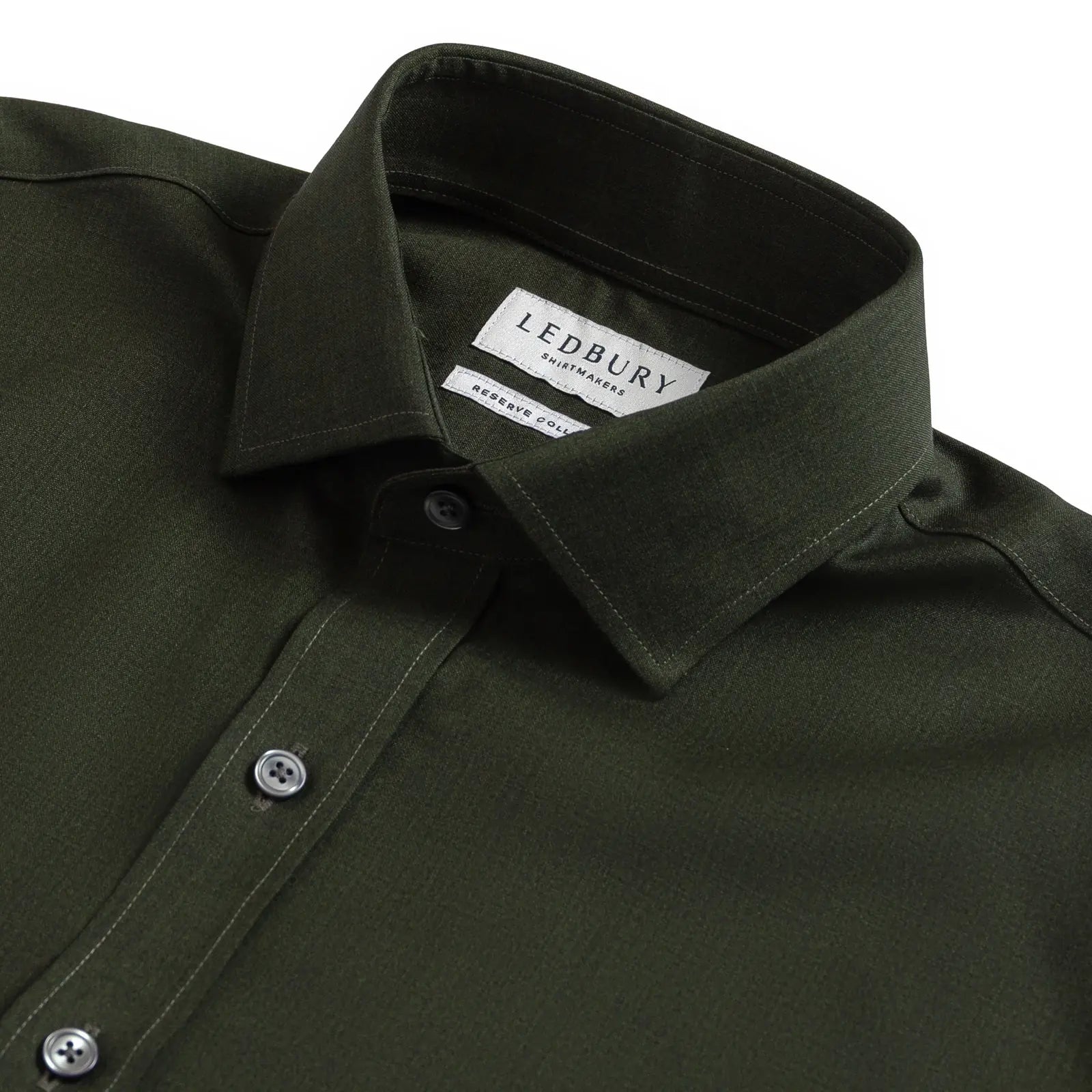 Close-up of a dark olive green LEDBURY long-sleeve shirt, showing the collar, button-down front, and LEDBURY brand label.