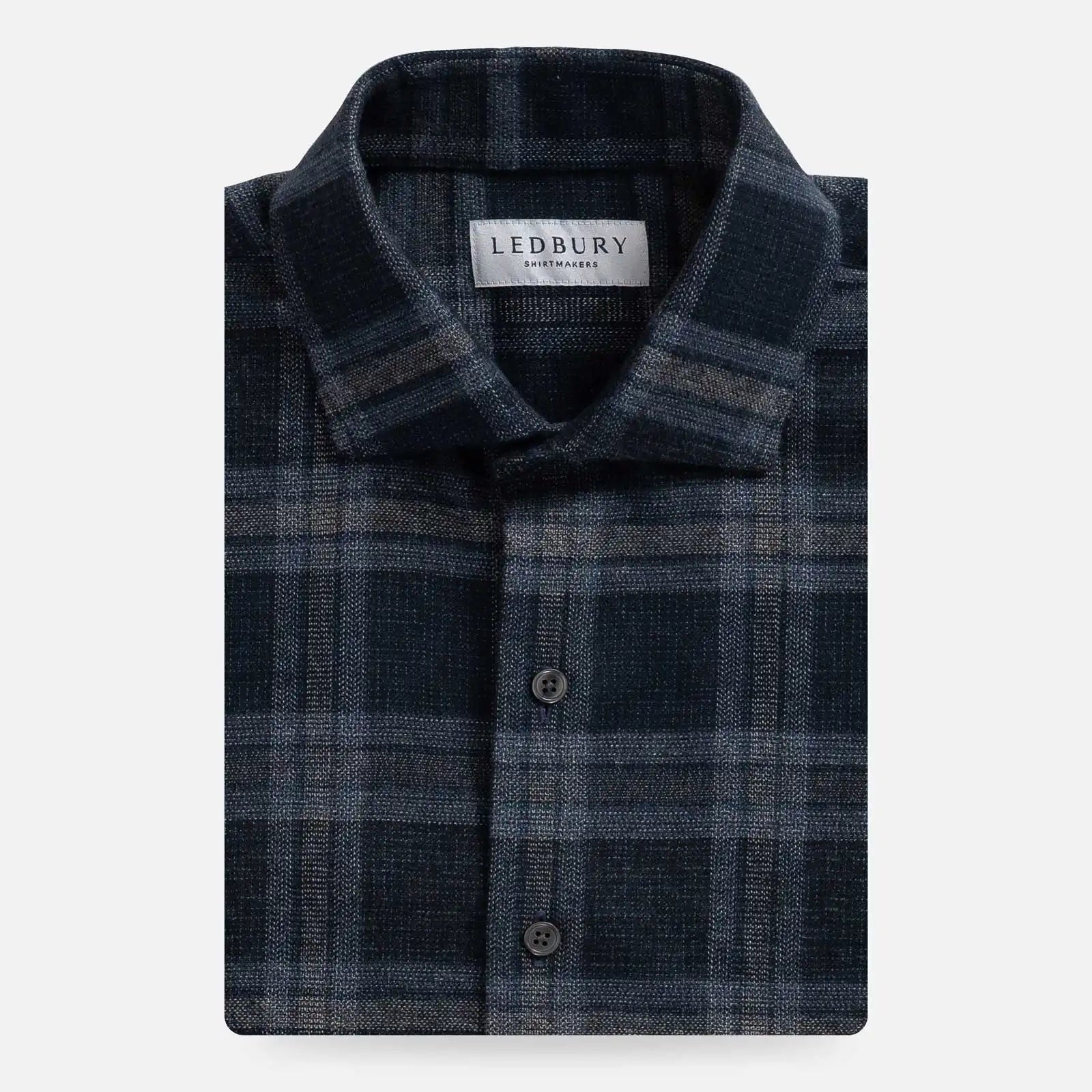 Folded plaid navy blue and dark grey shirt with 'Ledbury' label on a white background