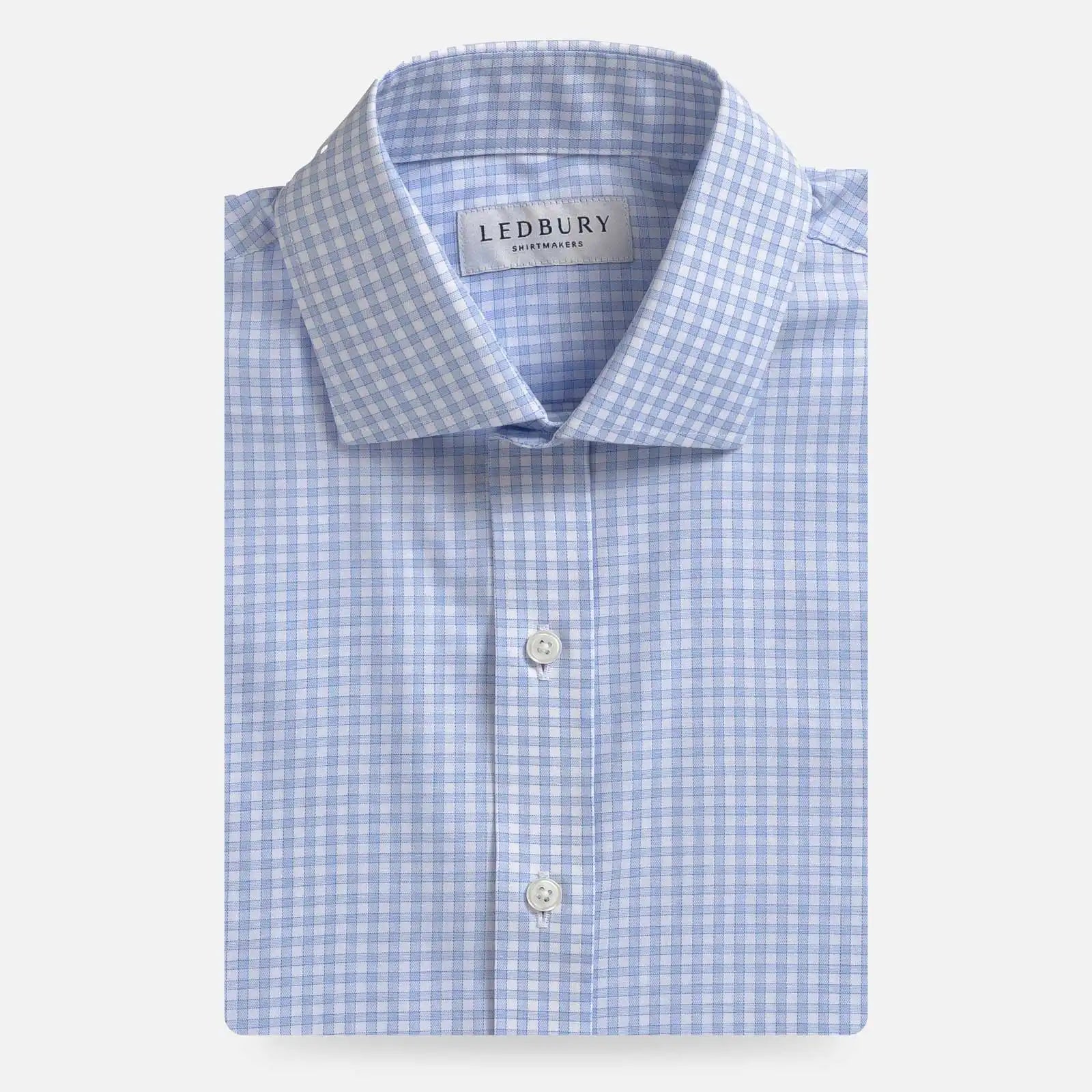 A folded light blue and white gingham dress shirt by Ledbury, featuring a classic collar, white buttons, and a clean white background.