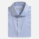A folded light blue and white gingham dress shirt by Ledbury, featuring a classic collar, white buttons, and a clean white background.