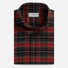 A folded long-sleeve plaid shirt by Ledbury, featuring a red, green, and black tartan pattern with thin white accent lines, on a light gray background.