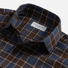 Close-up of a plaid button-down shirt collar with a visible LEDBURY brand label. The fabric is a mix of dark brown, slate blue, and thin white grid lines.