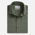 A folded men's dress shirt by Ledbury, featuring a green and white gingham check pattern with brown buttons, set against a plain light gray background.