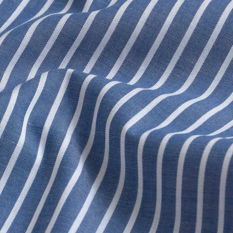 A close-up of blue fabric with evenly spaced white vertical stripes, showing a soft woven texture and gentle folds.
