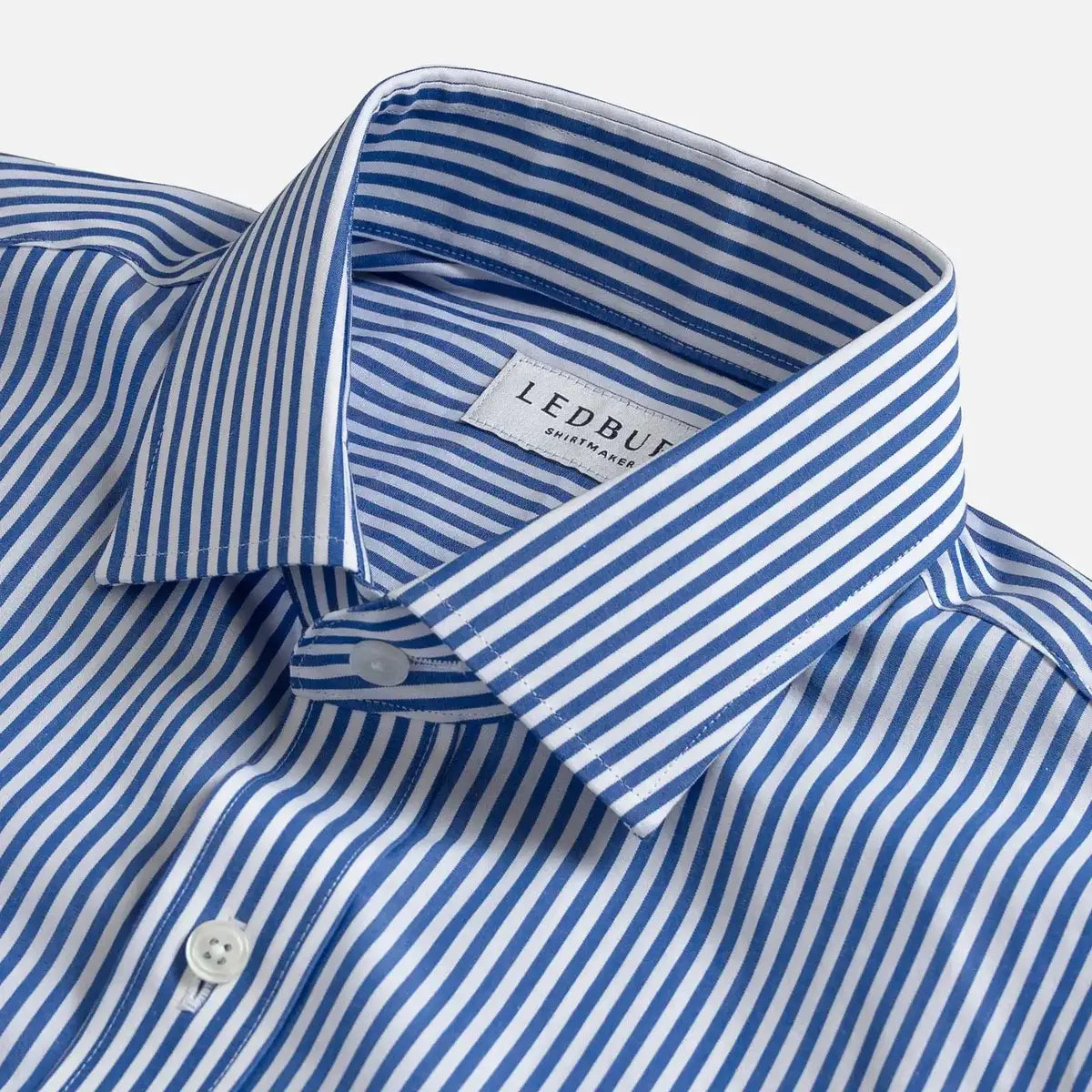 Close-up of a blue and white striped dress shirt collar with a visible LEDBURY label, shown on a light gray background.