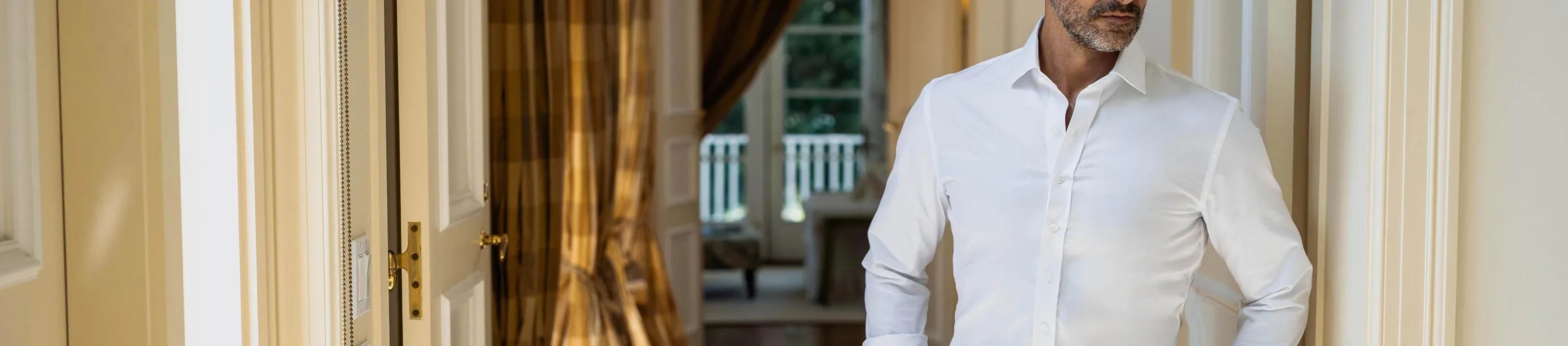 Man wearing a white dress shirt in a room with a blurred background