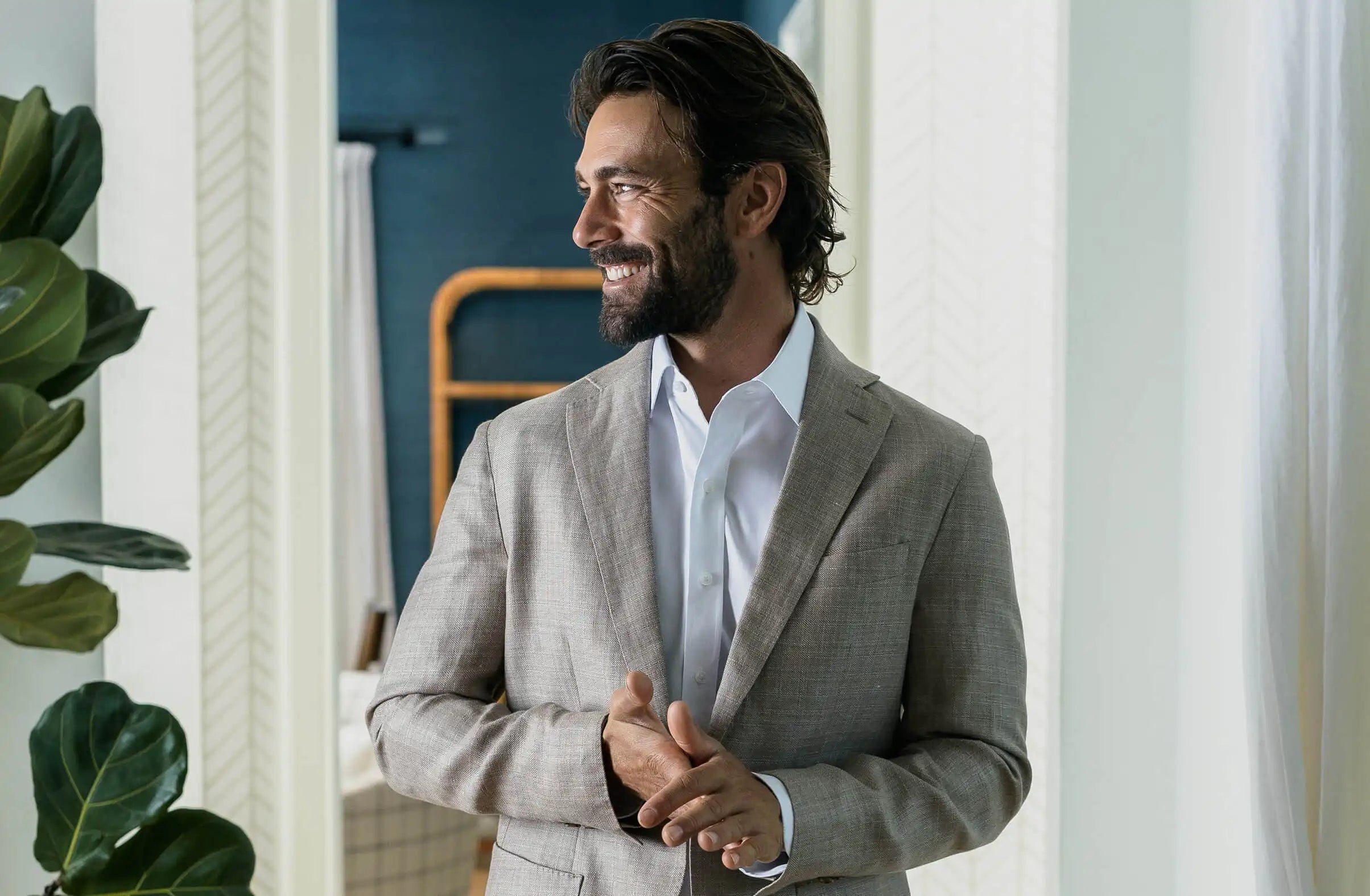 Model wearing a white Ledbury dress shirt and a tan suit