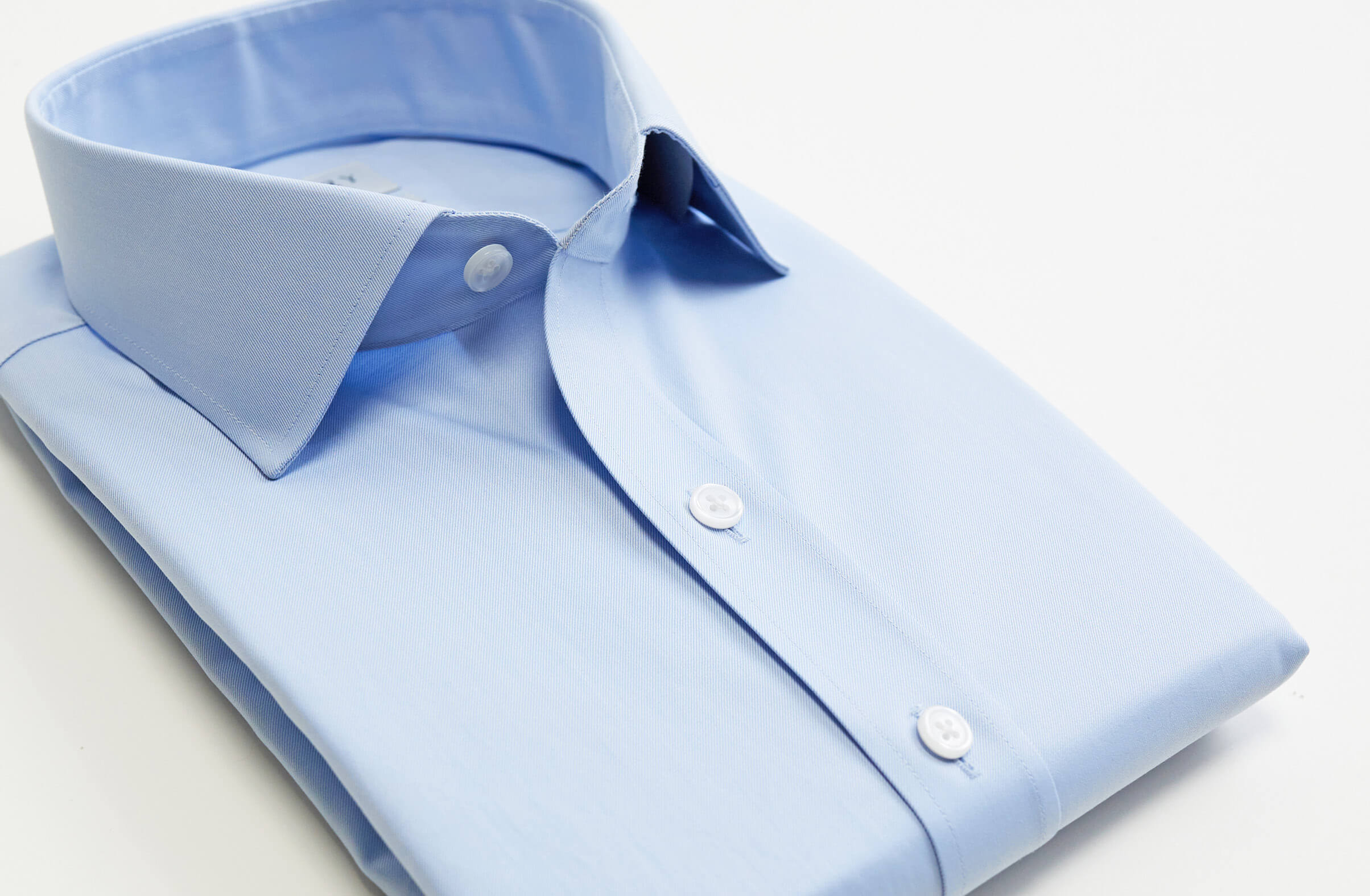 Ledbury light blue dress shirt, folded up on a flat surface. 