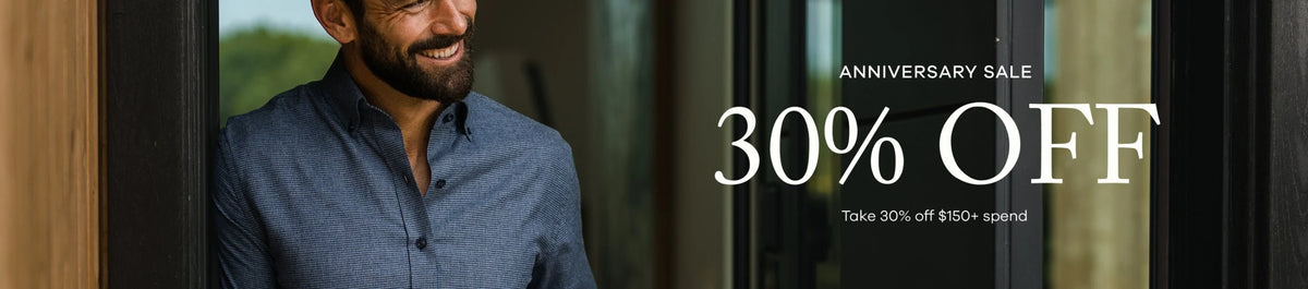 Promotional banner for an anniversary sale featuring a smiling man in a blue shirt standing by a glass door, with large white text reading 'ANNIVERSARY SALE 30% OFF'.