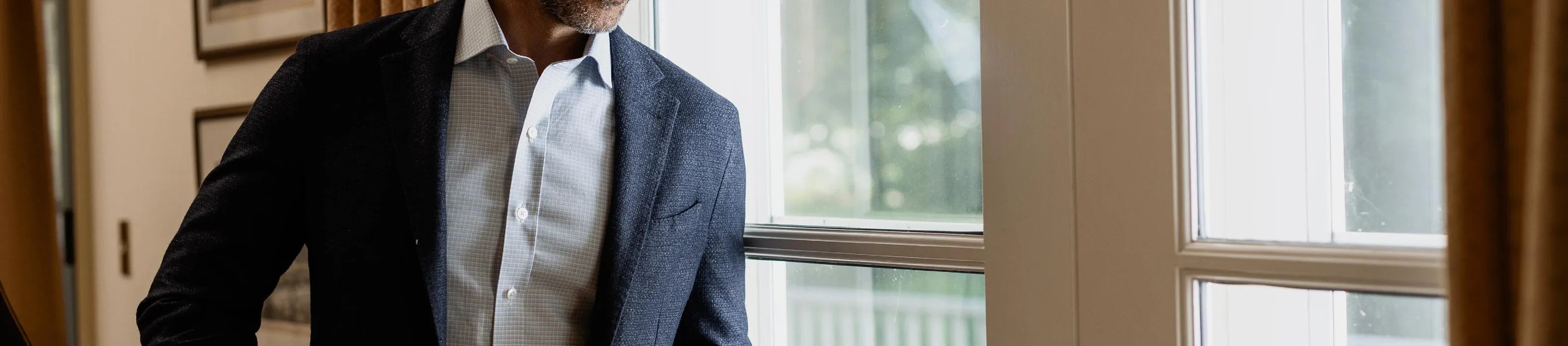 Man in a suit standing in front of a window
