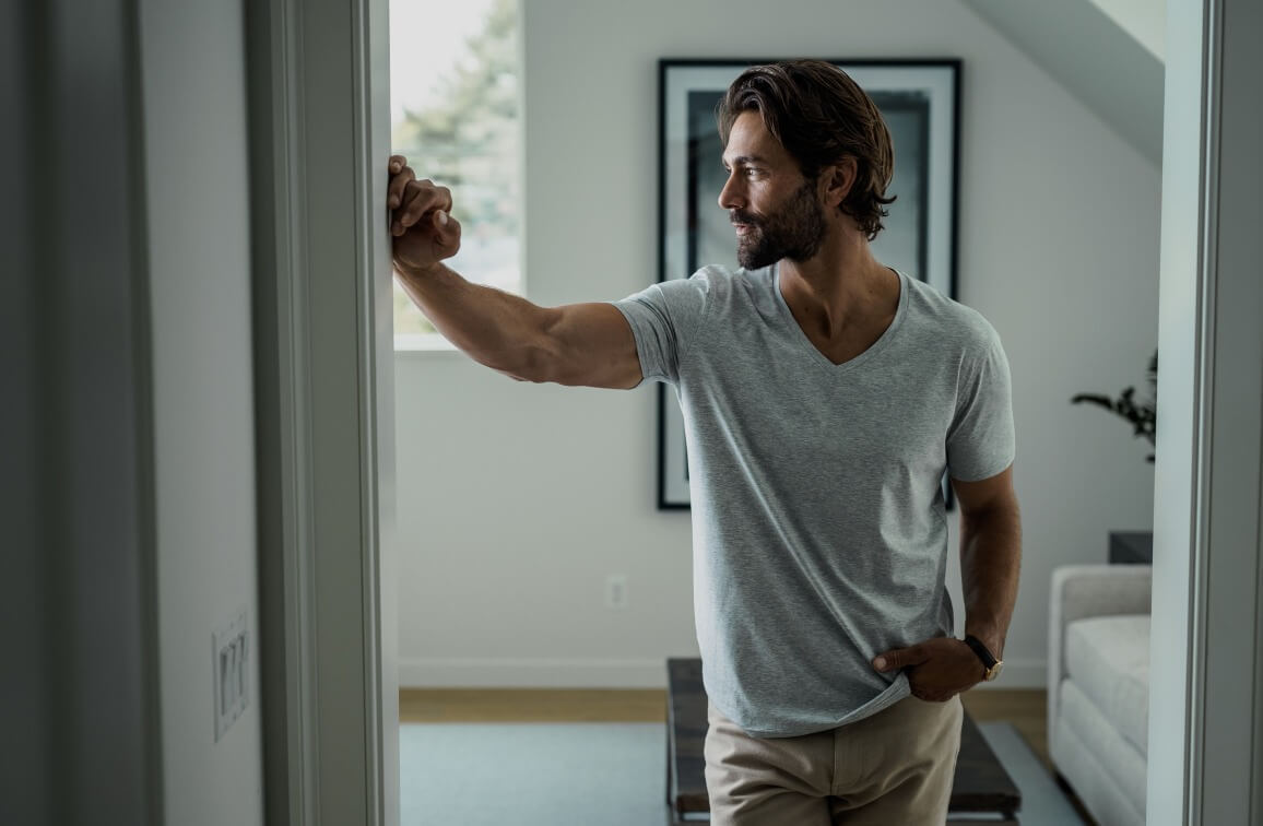 Model wearing the Ledbury grey v-neck undershirt, leaning against a doorway