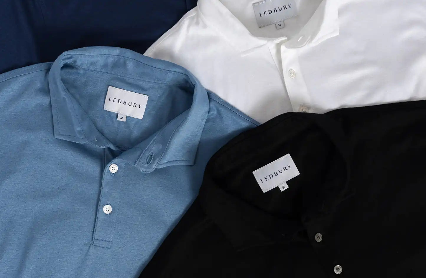 Image of Ledbury polos in various colors stacked on top of each other 