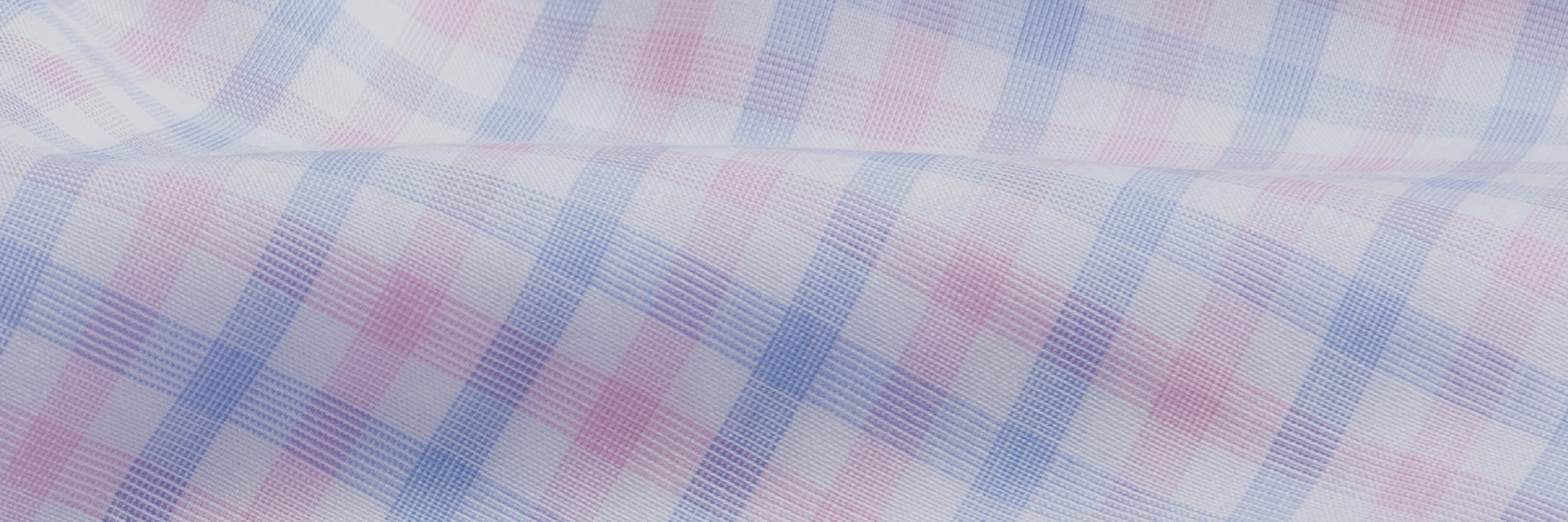 Closeup of the fabric of a light pink and light blue check men's dress shirt