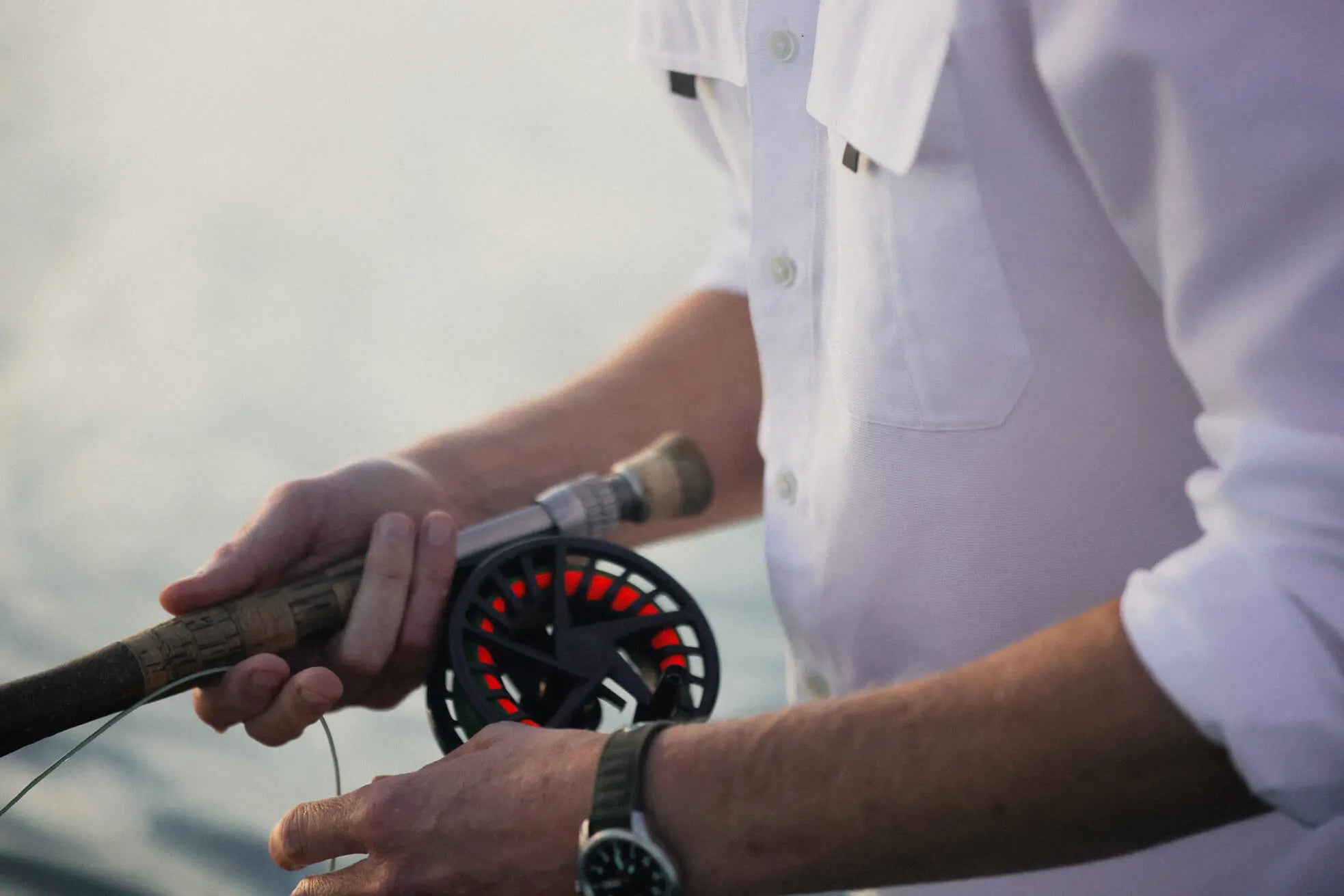 Person holding a fishing rod with a blurred background